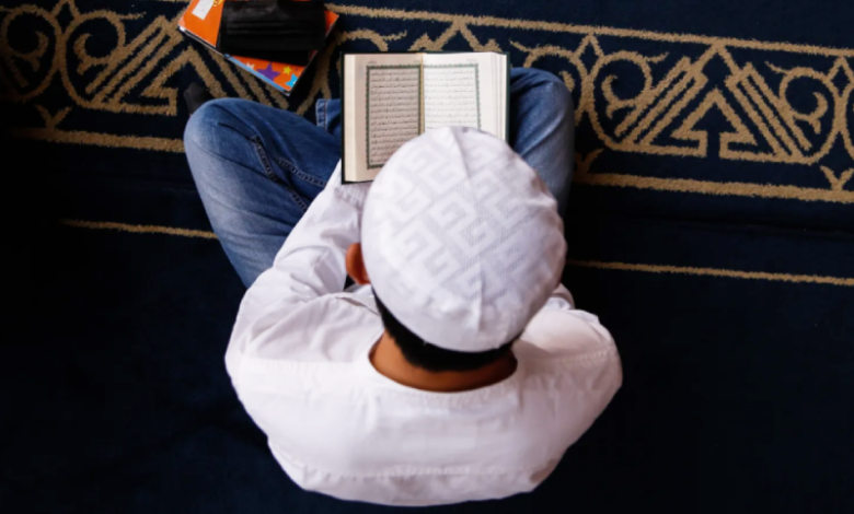 homme en train de lire le Qoran