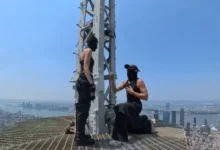 2 people reach the top of the Empire State Building and hang a 'power of love' banne