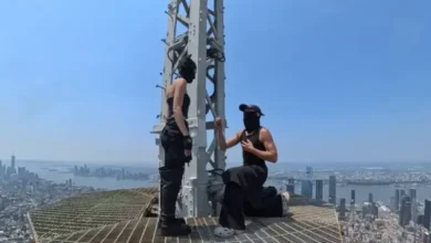2 people reach the top of the Empire State Building and hang a 'power of love' banne